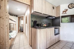 a kitchen with wooden cabinets and a counter top at Appartement vue montagne - Chatel in Châtel +13 photos