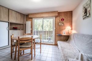 a kitchen and dining room with a table and a bed at Appartement vue montagne - Chatel in Châtel