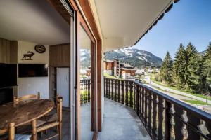 a balcony with a table and a view of the mountains at Appartement vue montagne - Chatel in Châtel