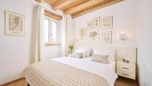 a white bedroom with a bed with white sheets and pillows at Casa Pove by Villas Guide in Donje Baredine