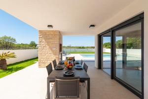 a dining room with a table and chairs on a patio at Villa Antonio ZadarVillas in Nin