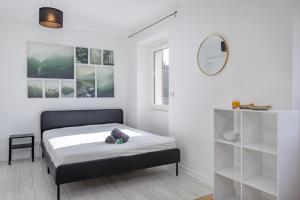a white room with a bed and a mirror at COLIVING - bedroom - TV- Private Bathroom in Saint-Jean-de-Gonville