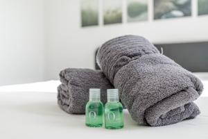 a towel animal with two bottles on a table at COLIVING - bedroom - TV- Private Bathroom in Saint-Jean-de-Gonville