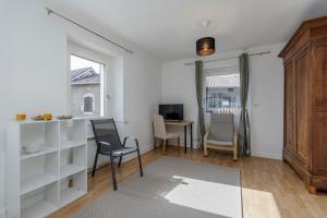 a living room with white cabinets and a table and chairs at COLIVING - bedroom - TV- Private Bathroom in Saint-Jean-de-Gonville