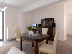 a dining room with a wooden table and white chairs at Ohlerich Speicher App_ 02 in Wismar