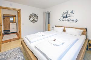 a large white bed with two white towels on it at Freigeist in Nesselwang