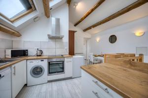 a kitchen with white appliances and a wooden counter top at COLIVING - bedroom - TV- Private Bathroom in Saint-Jean-de-Gonville +31 photos