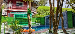 a house with a swimming pool in front of a house at GOLDEN GREEN RESORT WITH Pool in Munnar