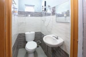 a bathroom with a toilet and a sink at Hotel O D'noor in Kota Bharu