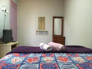 a bedroom with a bed with two towels on it at Hotel O D'noor in Kota Bharu