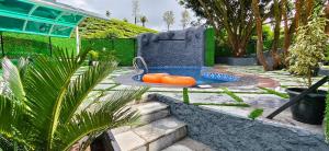 a pool with an orange raft in a garden at GOLDEN GREEN RESORT WITH Pool in Munnar