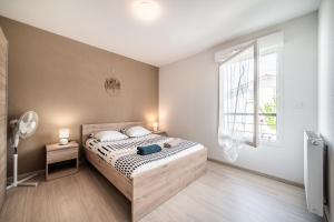 a bedroom with a bed and a window at Le Cocon in Thonon-les-Bains
