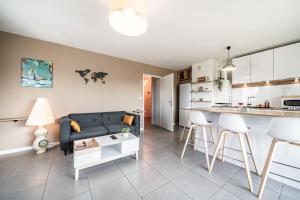 a living room and kitchen with a couch and a table at Le Cocon in Thonon-les-Bains