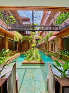 a courtyard with a swimming pool in a building at Baliris Home Boutique Legian in Seminyak