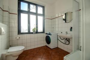 a bathroom with a toilet a sink and a washing machine at Zentral & ruhig - Stadt, Elbe und Natur nebenan in Magdeburg
