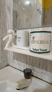 a bathroom with a shelf with a cup and a toilet tissue at Romance in Bay in Arugam Bay