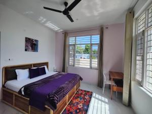 ein Schlafzimmer mit Bett, Fenster und Schreibtisch in der Unterkunft CloudHaus Bir Private 3BHK Villa Mountain Views in Bir