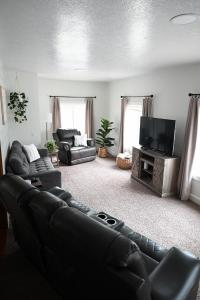 a living room with a couch and a flat screen tv at Pondside Abode in Dundee