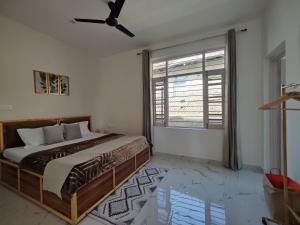ein Schlafzimmer mit einem Bett und einem großen Fenster in der Unterkunft CloudHaus Bir Private 3BHK Villa Mountain Views in Bir + 5 Fotos