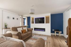 a living room with a couch and a fireplace at The Old Hay Barn, Hot Tub, Pet Friendly in Ludgvan