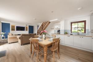 a kitchen and living room with a table and chairs at The Old Hay Barn, Hot Tub, Pet Friendly in Ludgvan