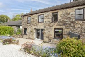 a stone house with a garden in front of it at The Old Hay Barn, Hot Tub, Pet Friendly in Ludgvan