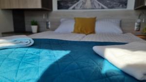 a bedroom with a bed with a blue blanket at Srebrna Wydma in Dąbki