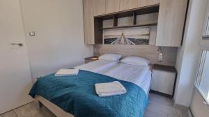 a bedroom with a bed with two towels on it at Srebrna Wydma in Dąbki +154 photos