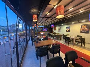 a restaurant with tables and chairs and windows at Arya Apart Kundu Hotel in Lara