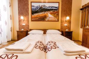 a bedroom with two beds and a painting on the wall at Dom Wczasowy Na Szczycie in Zakopane