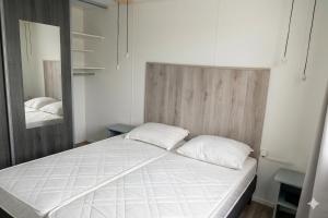 a bed with two pillows in a room with a mirror at Prins Chalets Hoogersmilde Drenthe in Hoogersmilde
