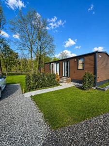a house with a car parked in front of it at Prins Chalets Hoogersmilde Drenthe in Hoogersmilde