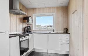 a kitchen with white cabinets and a window at Awesome Home In Haderslev With Sauna in Haderslev +16 photos