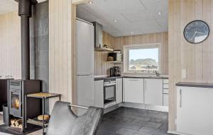 a kitchen with white appliances and a fireplace at Awesome Home In Haderslev With Sauna in Haderslev
