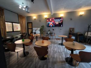 a restaurant with tables and chairs and a tv on the wall at O'soho GarDens BingerVille in Bingerville