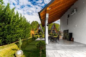 a house with a patio with tables and chairs at Casute A frame in Jiblea Veche