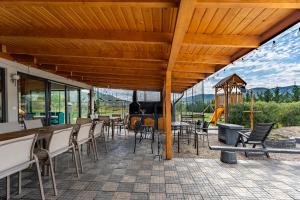 a patio with tables and chairs with a view of the mountains at Casute A frame in Jiblea Veche