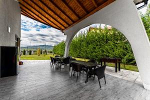 a patio with a table and chairs and a piano at Casute A frame in Jiblea Veche