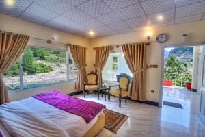 a bedroom with a bed and a table and chairs at Parhena Cottages Bella Naran in Naran +64 photos