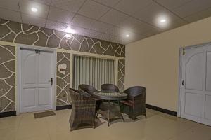 a table and chairs in a room with a wall at Parhena Cottages Bella Naran in Naran