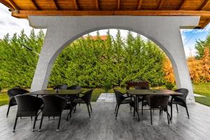an outdoor patio with tables and chairs and an archway at Casute A frame in Jiblea Veche +17 photos