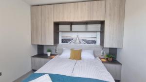 a bedroom with a large white bed with a window at Srebrna Wydma in Dąbki