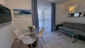 a living room with a table and a couch at Srebrna Wydma in Dąbki