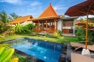 a villa with a swimming pool in front of a house at Shankara D'Uma in Ubud +18 photos