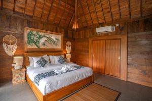 a bedroom with a bed in a wooden room at Shankara D'Uma in Ubud