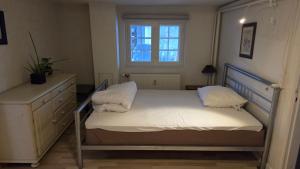 a small bedroom with a bed and a window at Gamle Præstegård, viceværtlejlighed in Årup