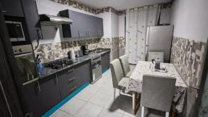 a kitchen with a table and chairs and a refrigerator at Spacious accommodation with city views in Haï Khemisti