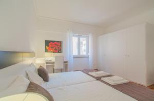 um quarto branco com uma cama grande e uma secretária em City Center Stylish Apartment em Lisboa