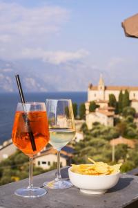 two glasses of wine and a bowl of food on a table at Hotel Pace in Brenzone sul Garda
