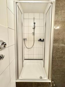 a shower in a white tiled bathroom at Charmante Wg im Stadtgeflüster in Schwäbisch Hall +4 photos